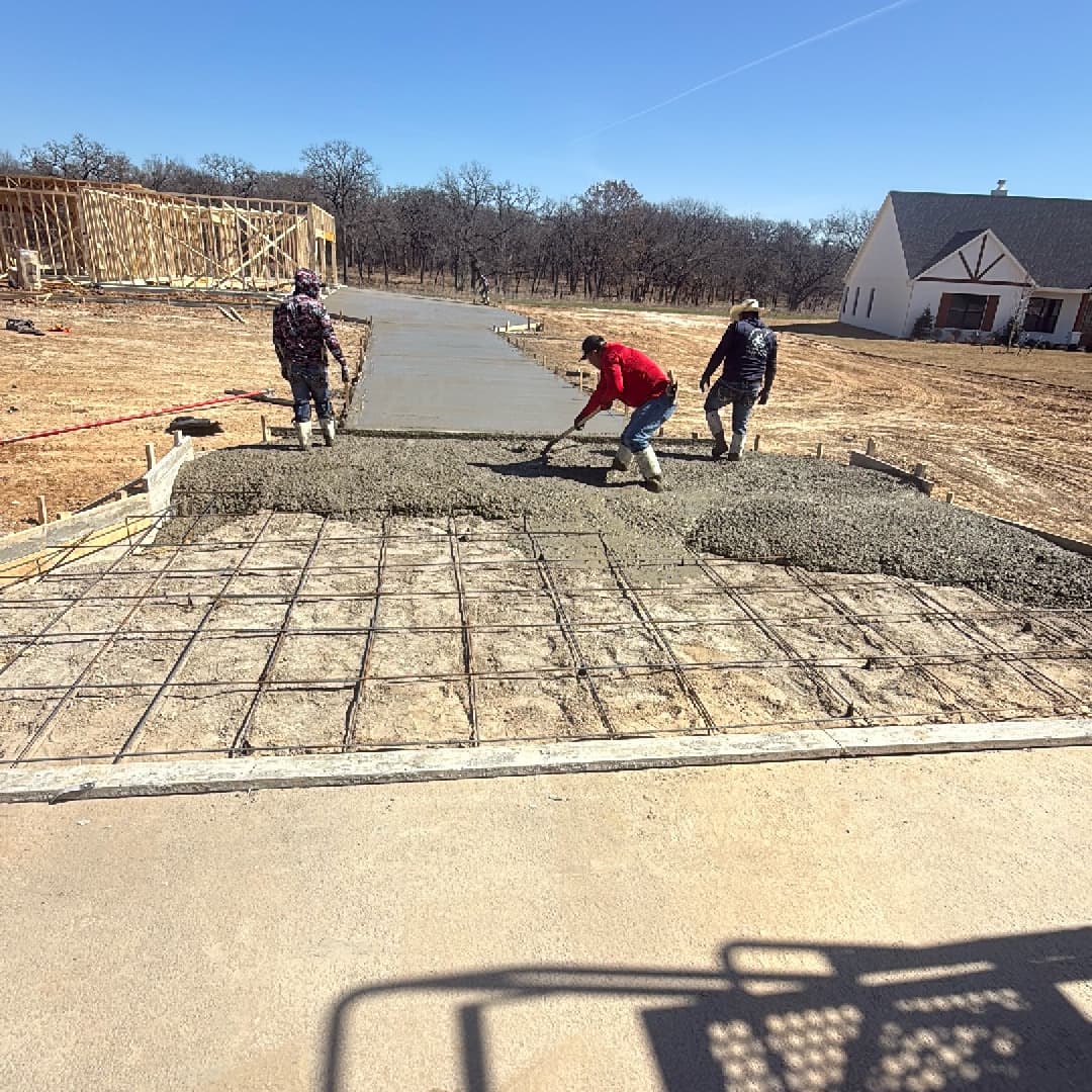 Crew pouring concrete driveway with rebar reinforcement in North Texas