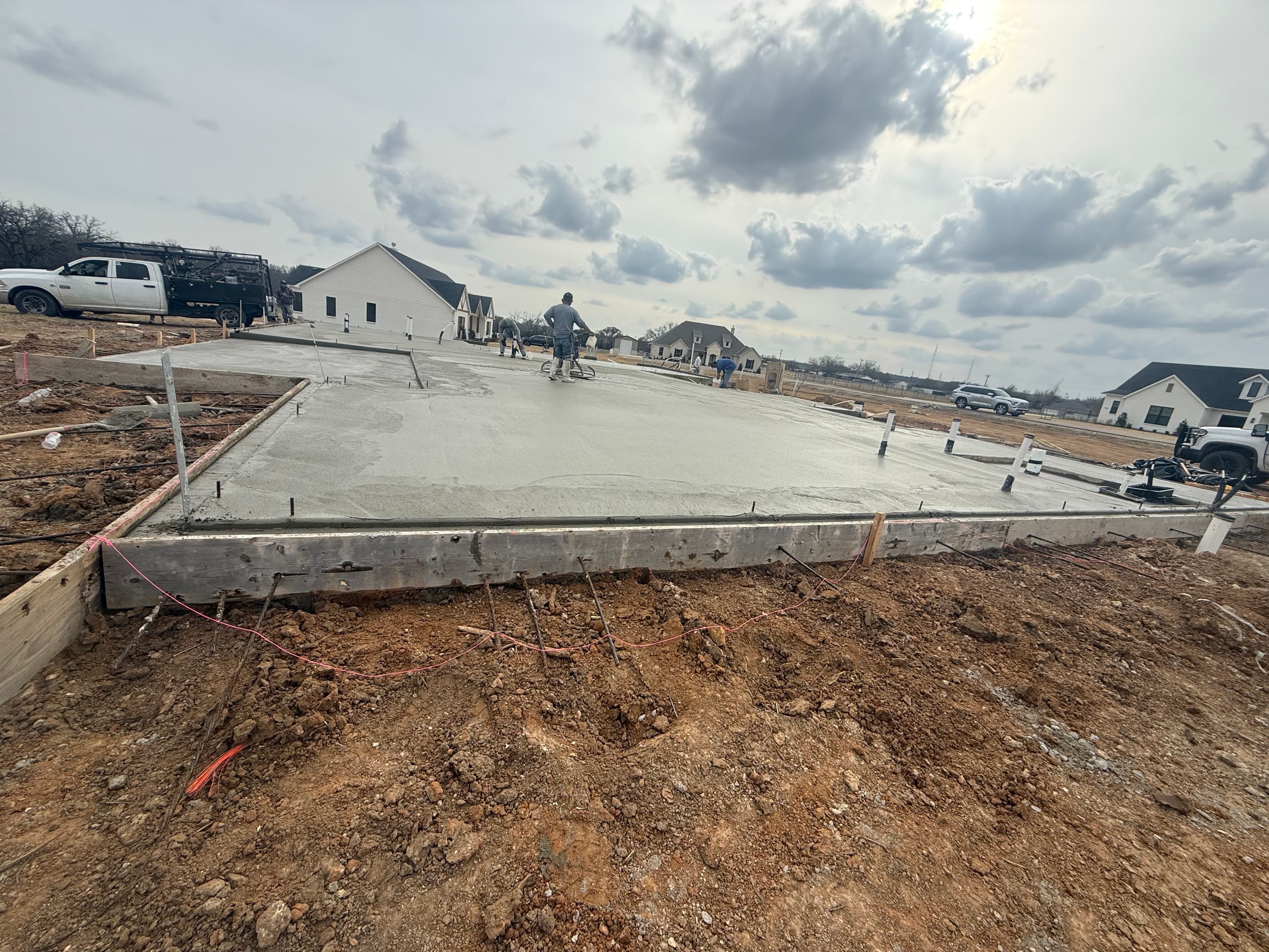 Crew finishing a residential concrete foundation pour in North Texas