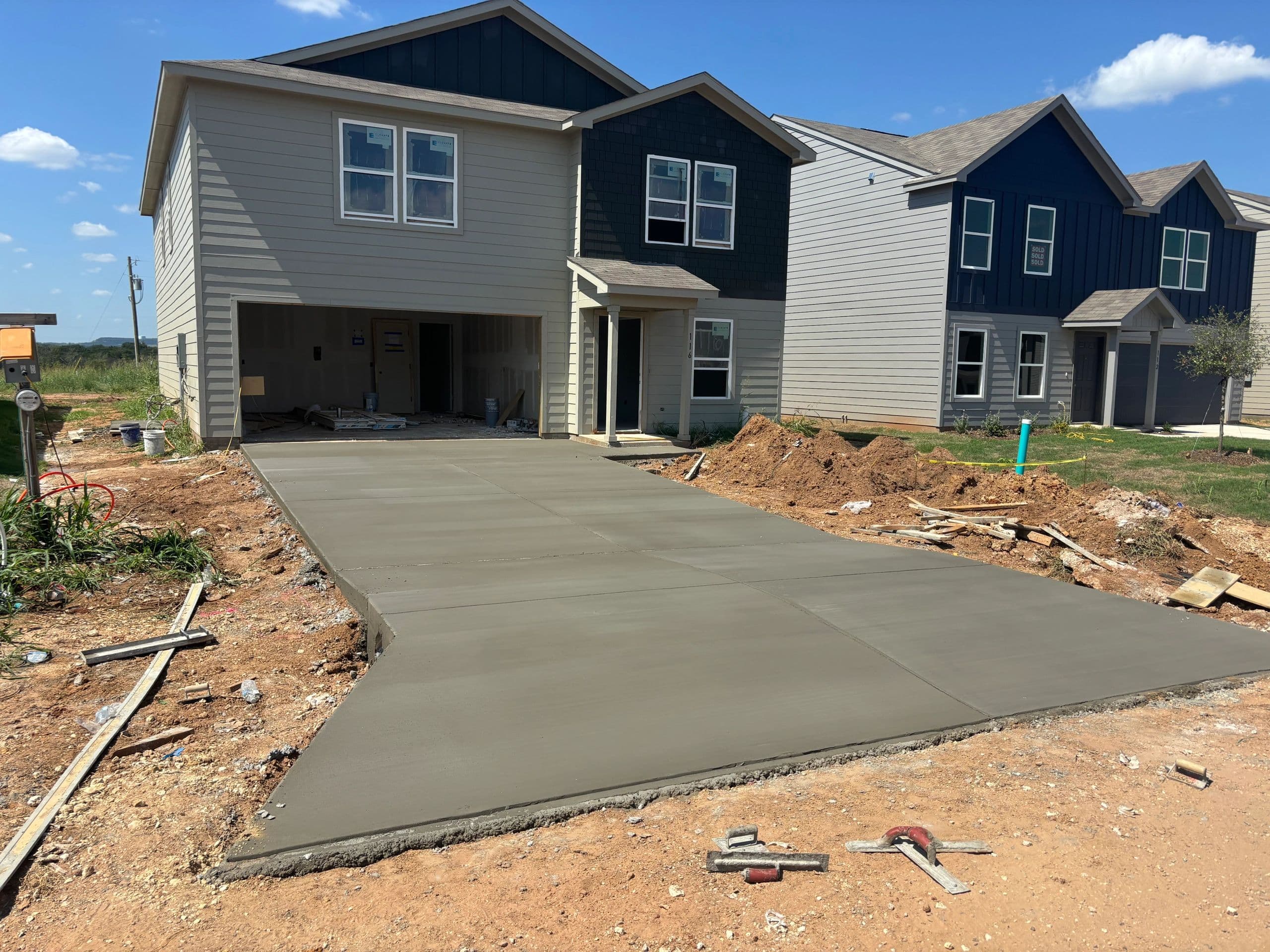 Fresh residential concrete driveway, North Texas subdivision
