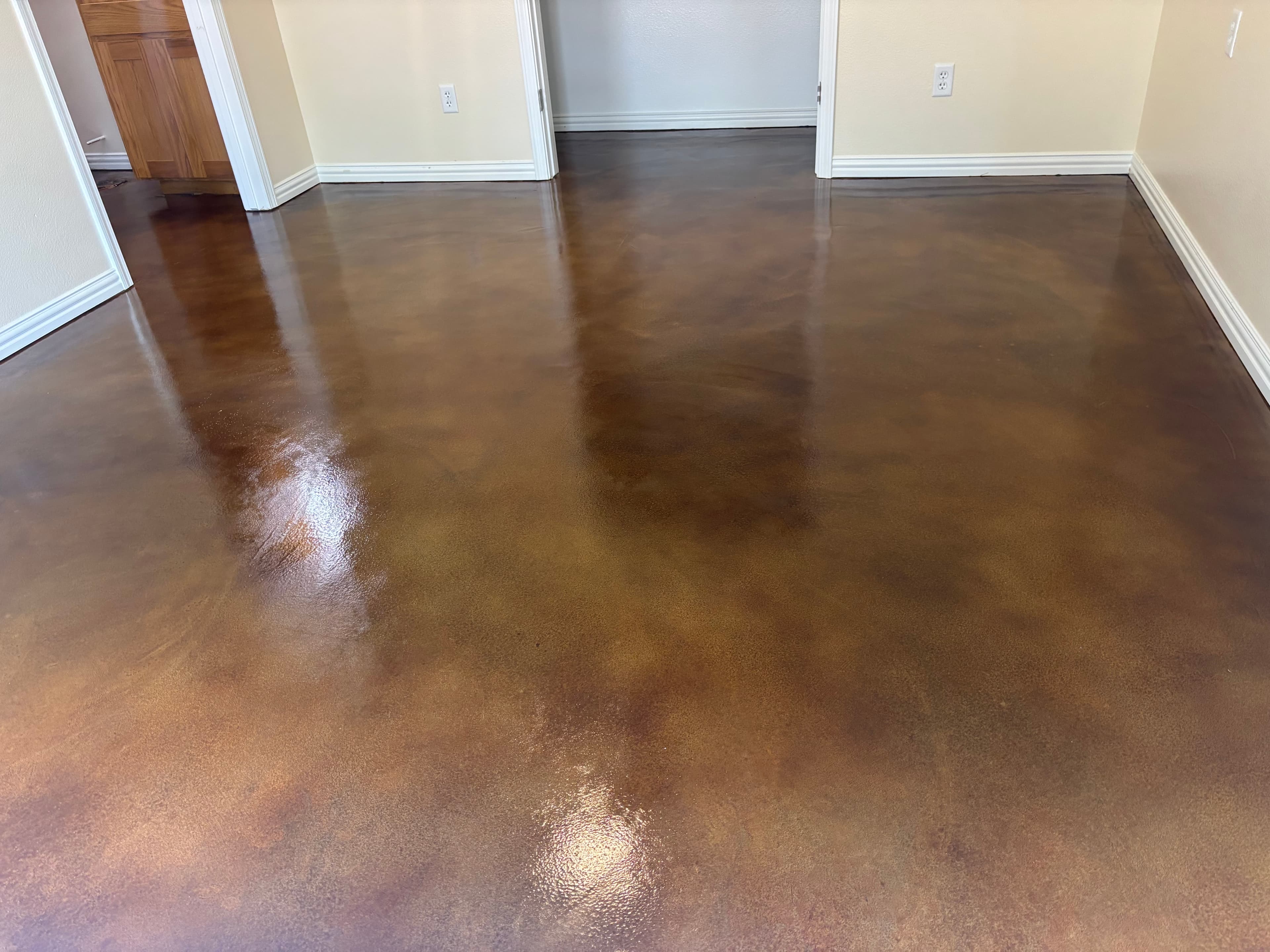 Stained concrete floor after resurfacing — rich brown tones